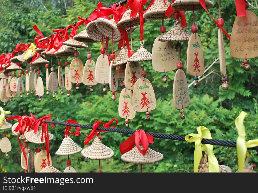 Hanging wish and prayer Chinese ornaments along steel cables over a soft forest background in Yanoda national park. Shallow depth-of-field. Hanging wish and prayer Chinese ornaments along steel cables over a soft forest background in Yanoda national park. Shallow depth-of-field