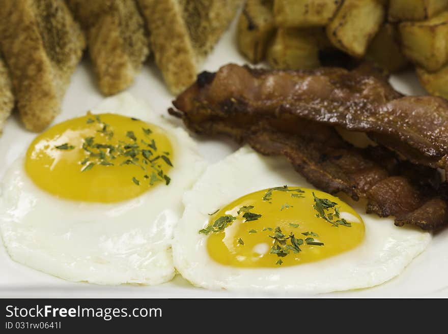 Breakfast meal on a white plate with two eggs,potato,toasted bread and bacon.

Orientation : horizontal
Concept : mealtime,food,morning. Breakfast meal on a white plate with two eggs,potato,toasted bread and bacon.

Orientation : horizontal
Concept : mealtime,food,morning