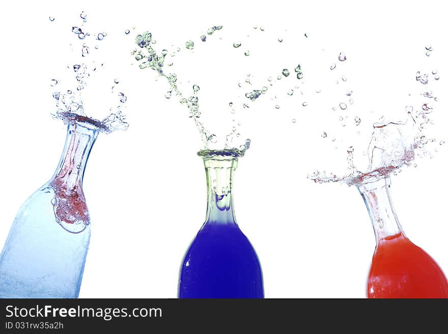 Water drops shooting out of three bottles