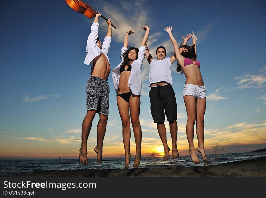 Happy young friends group have fun and celebrate while jumping and running on the beach at the sunset. Happy young friends group have fun and celebrate while jumping and running on the beach at the sunset