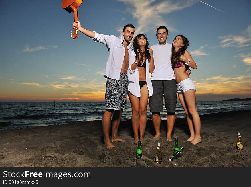 Happy young friends group have fun and celebrate while jumping and running on the beach at the sunset. Happy young friends group have fun and celebrate while jumping and running on the beach at the sunset