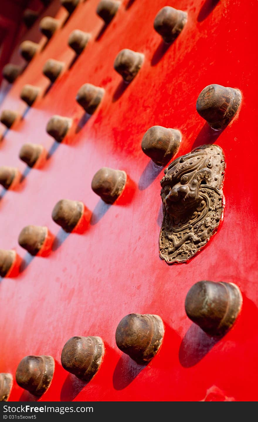 A large wooden door with an oriental door knocker. A large wooden door with an oriental door knocker.