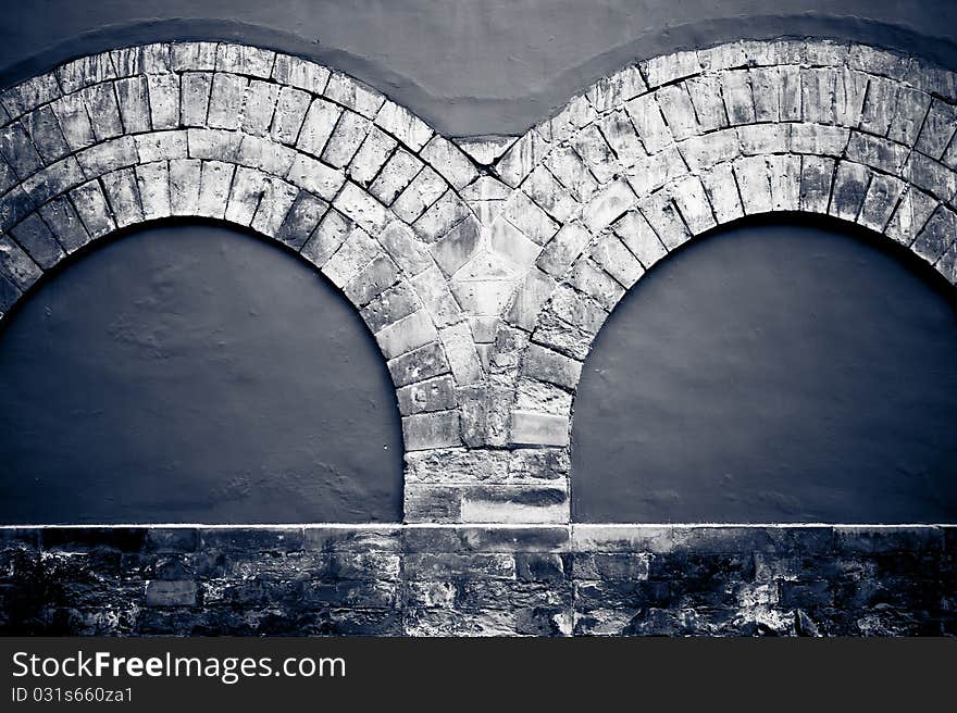 A double stone arch decoration on a wall. A double stone arch decoration on a wall