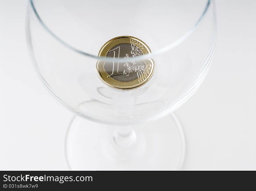 A one euro coin in a crystal glass. A one euro coin in a crystal glass