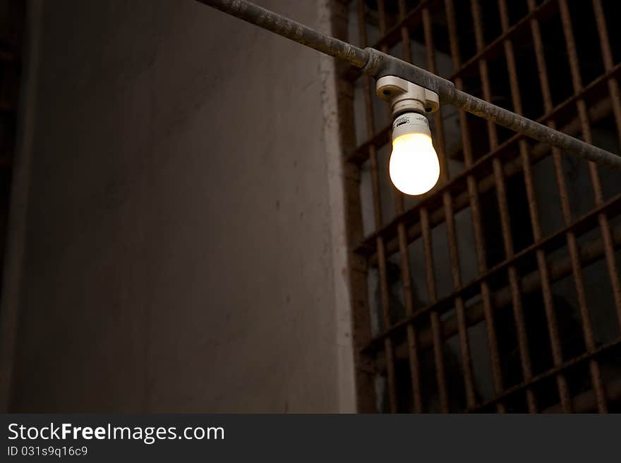 Single light bulb hanging in a prison corridor. Single light bulb hanging in a prison corridor