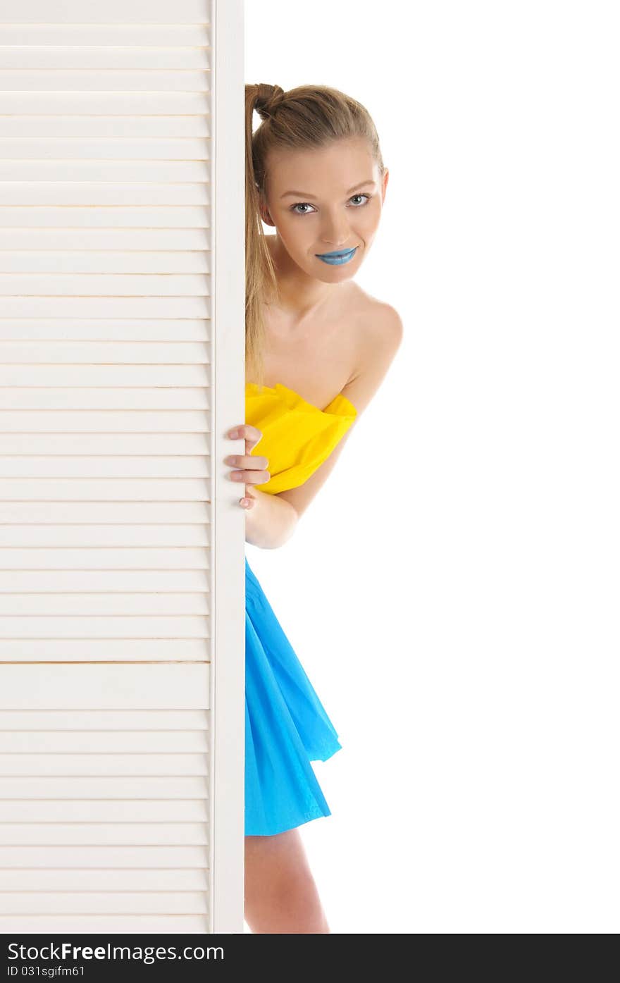 Young woman looks out because of door isolated in white