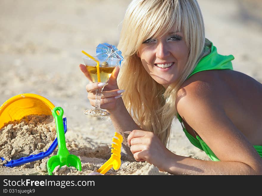 A beautiful girl at the sunny beach with martini glass