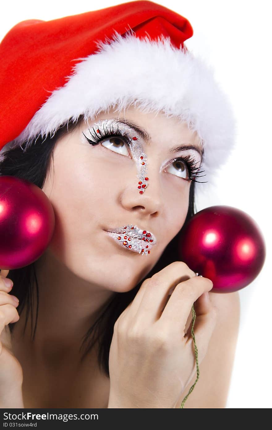 Female in christmass hat holds a red spheres