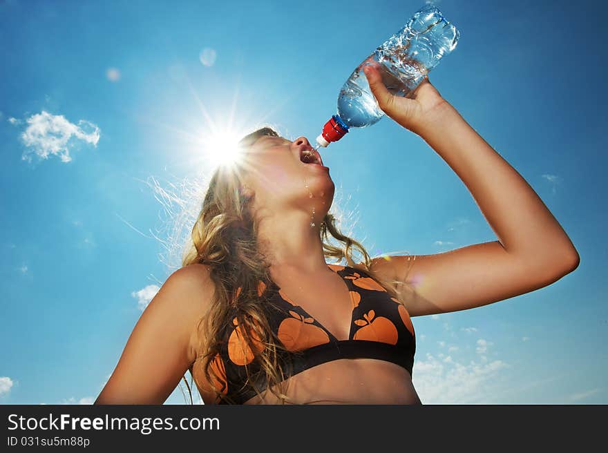 Young girl drinking water outdoors