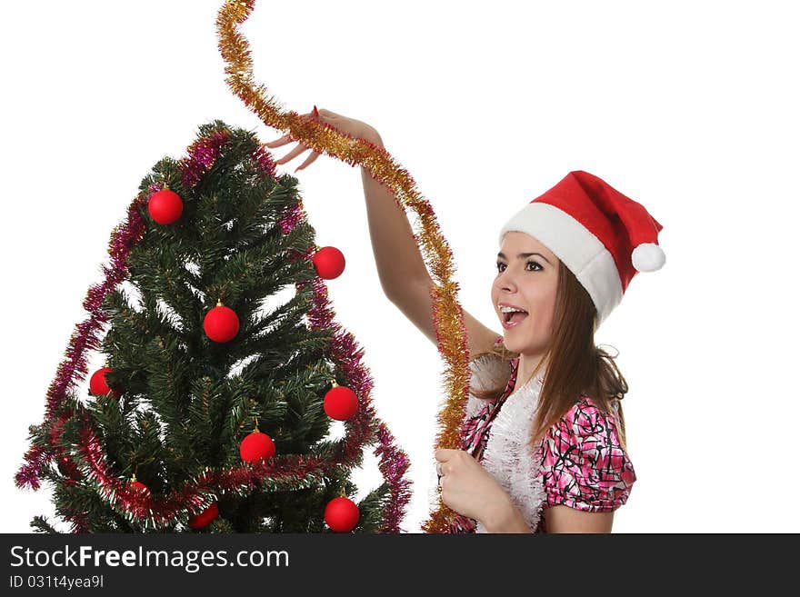 Woman in a christmas hat decorate a christmas tree. Woman in a christmas hat decorate a christmas tree