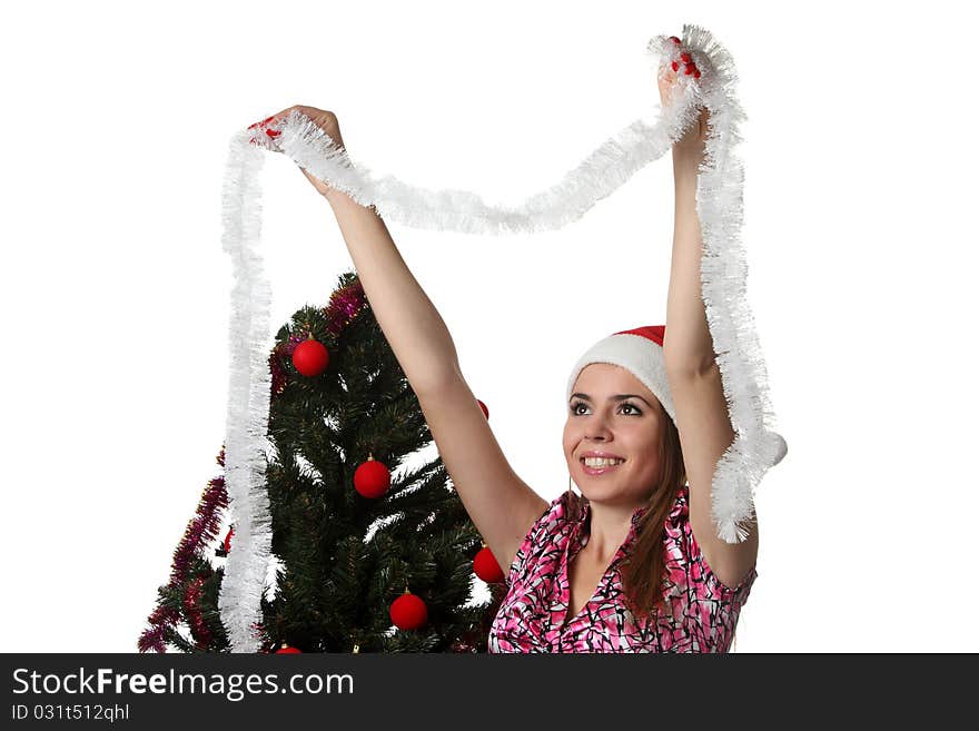 Woman in a Christmas hat decorate a Christmas tree. Woman in a Christmas hat decorate a Christmas tree