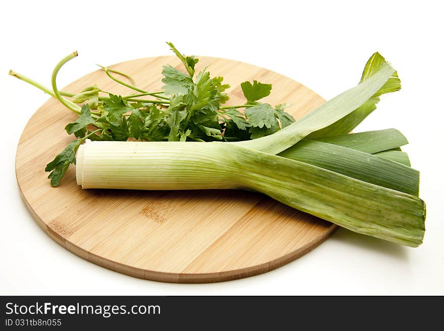 Leek and parsley on round wood plate