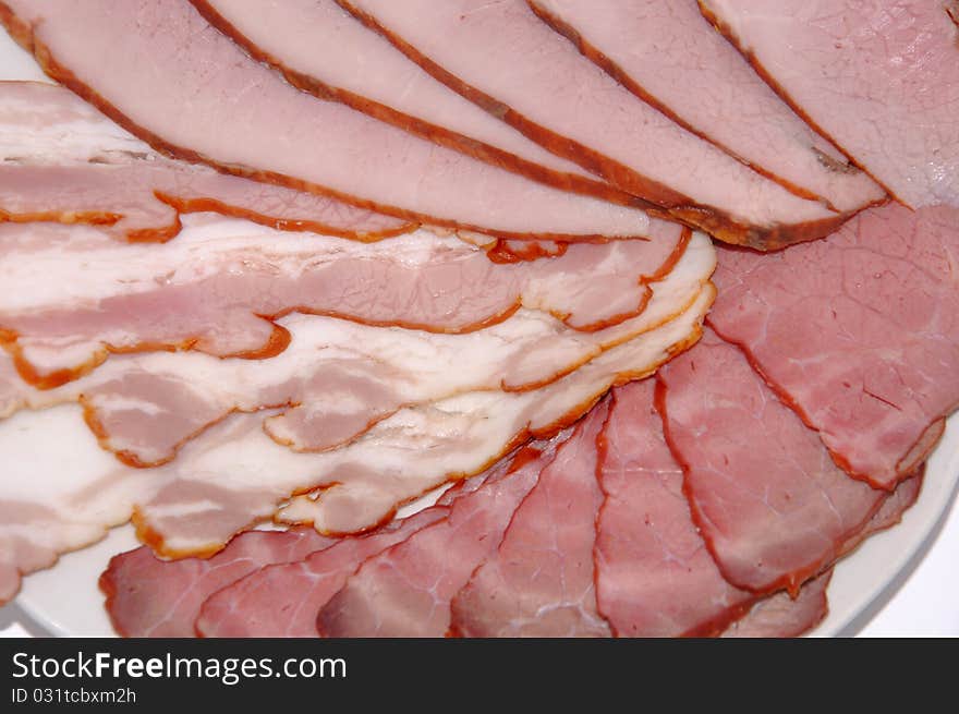 Meat cutting from a boiled pork and bacon on a white background