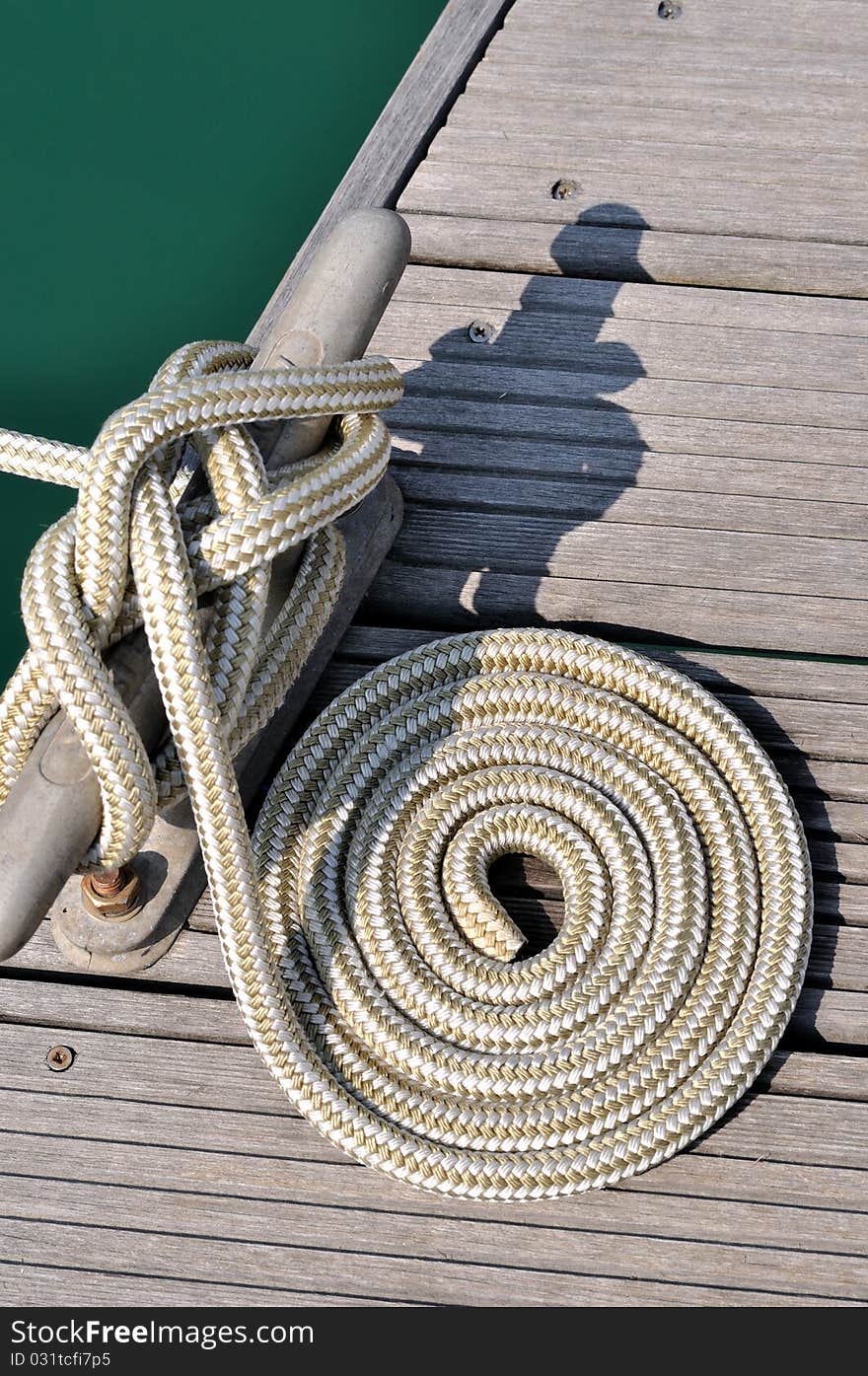 Rope of boat twist on dock board, as a circle, shown as maritime activities, sport or entertainment on sea. Rope of boat twist on dock board, as a circle, shown as maritime activities, sport or entertainment on sea.