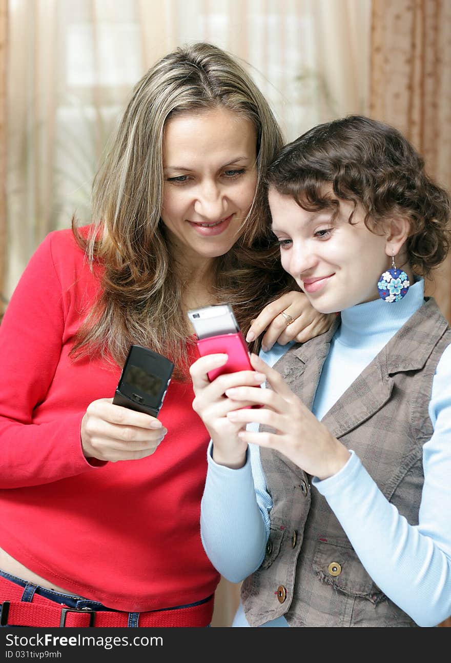 Two girls with mobile phones at home