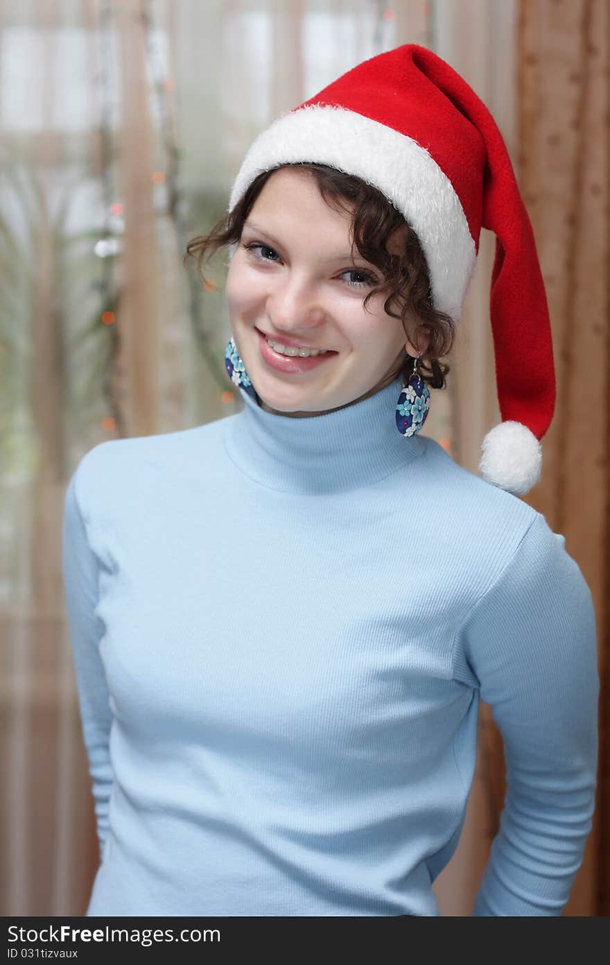 Young girl in a Christmas hat at home