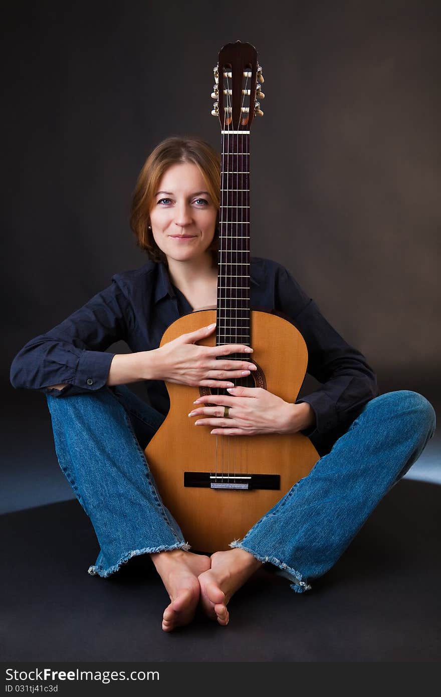 Portrait of the girl with a guitar on a black background. Portrait of the girl with a guitar on a black background