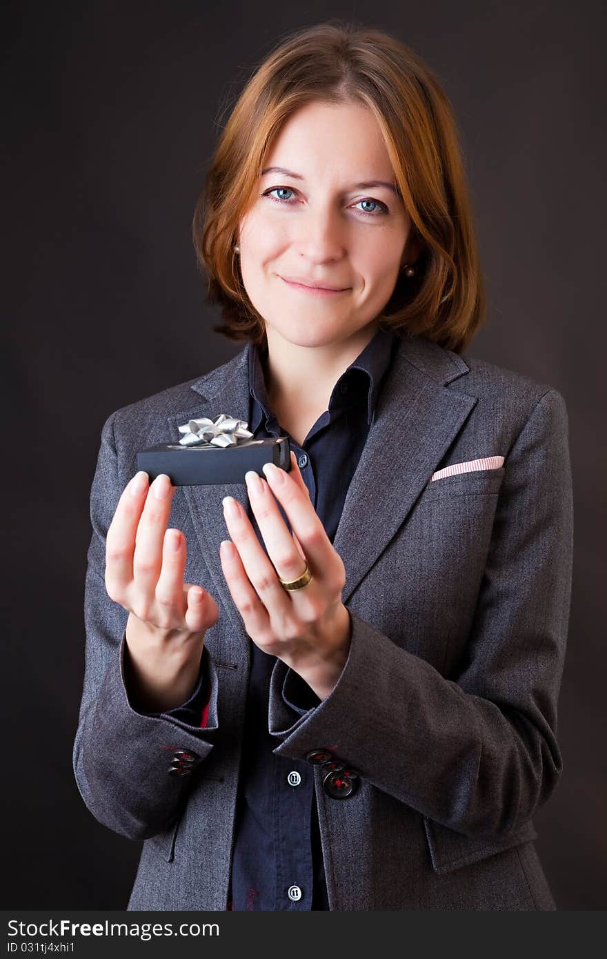 Girl in a business suit with a gift in a hands. Girl in a business suit with a gift in a hands