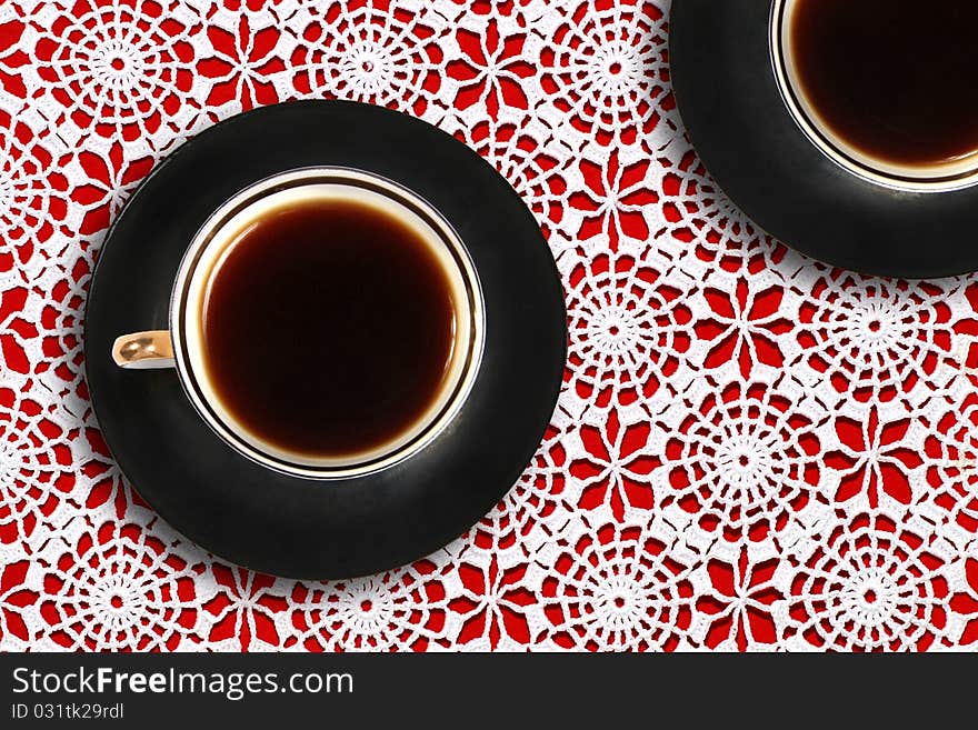 Two coffee cups on lace tablecloth