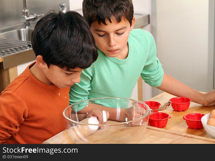 Two brothers standing in the kitchen and baking some christmas cookies. Two brothers standing in the kitchen and baking some christmas cookies