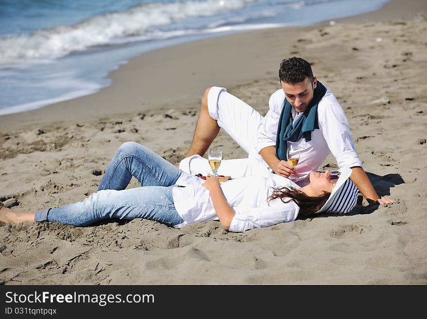 Happy young couple enjoying  picnic on the beach and have good time on summer vacations