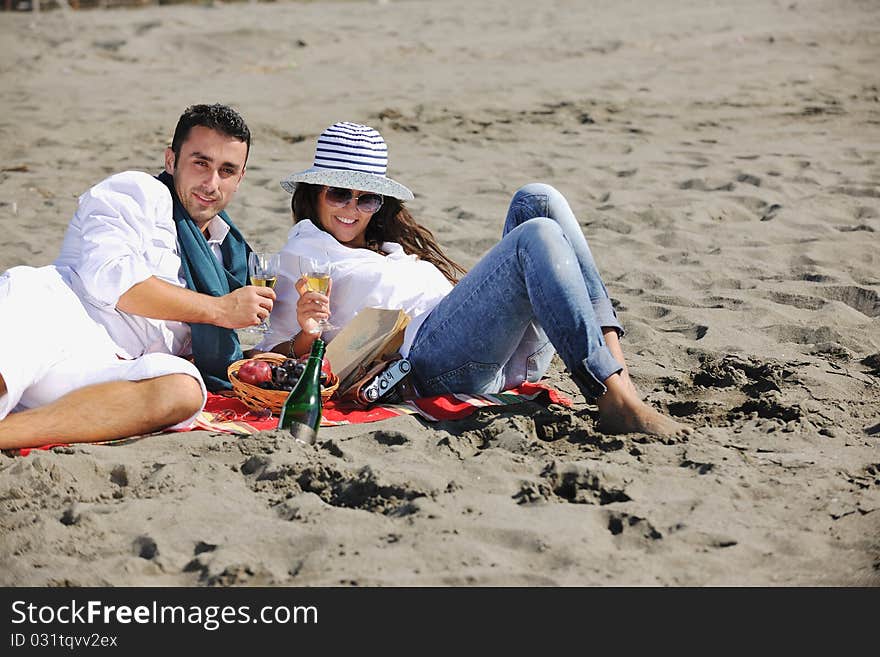 Young Couple Enjoying  Picnic On The Beach