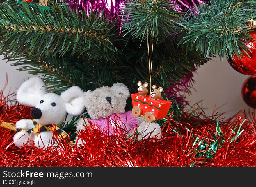 Tinsel, soft toys, balls and other trinkets under the christmas fir tree. Tinsel, soft toys, balls and other trinkets under the christmas fir tree.