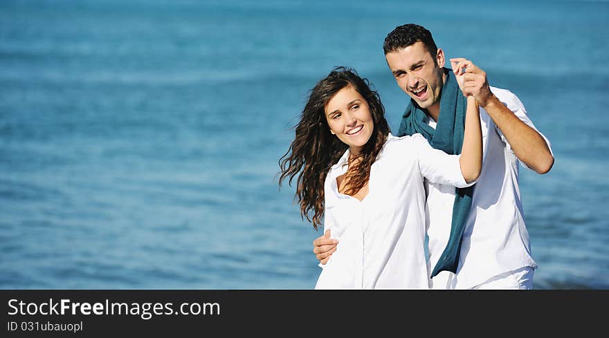 Happy young couple in white clothing have romantic recreation and fun at beautiful beach on vacations. Happy young couple in white clothing have romantic recreation and fun at beautiful beach on vacations