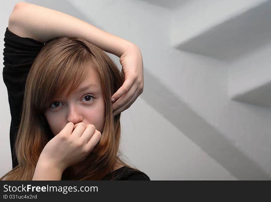 Nice young girl portrait on gray background with staircase