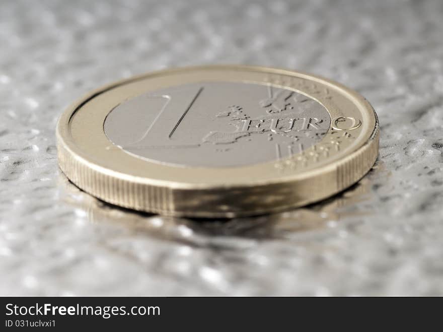 A one euro coin on a flat metal. A one euro coin on a flat metal