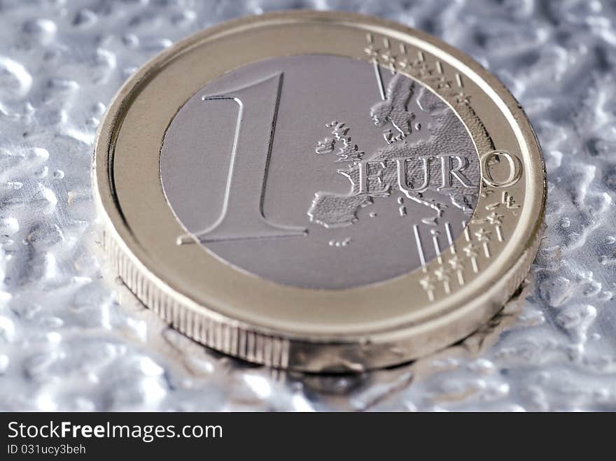 A one euro coin on a flat metal. A one euro coin on a flat metal