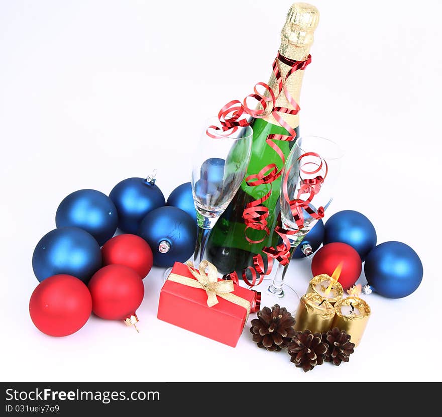 Christmas and New Year's theme -  a bottle of champagne, glasses, candles, a gift, and cones on white backgrond