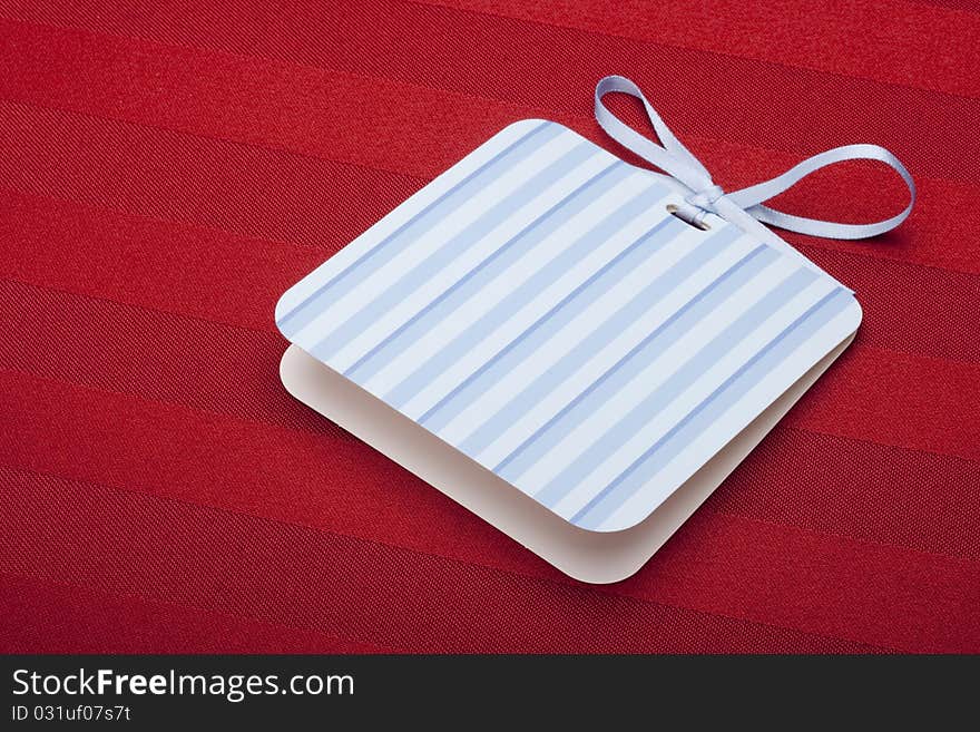 Greeting card with a blue ribbon on a red background.