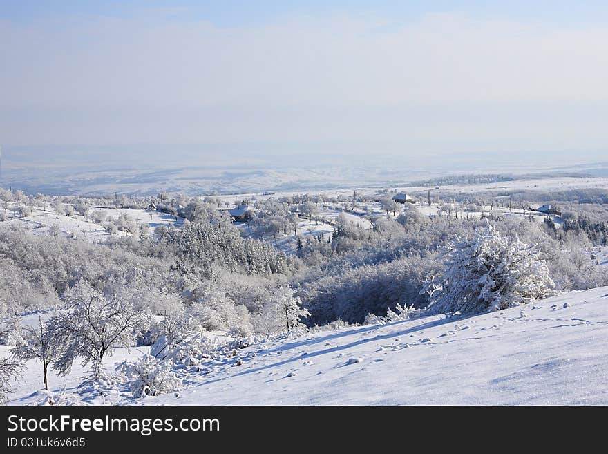 Snowy landscape on a hill with some houses in mid-plane. Snowy landscape on a hill with some houses in mid-plane