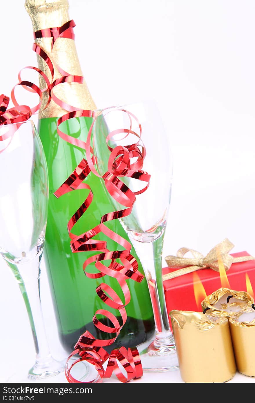 Christmas and New Year's setting - a bottle of champagne, glasses, candles, a gift, on white background. Christmas and New Year's setting - a bottle of champagne, glasses, candles, a gift, on white background