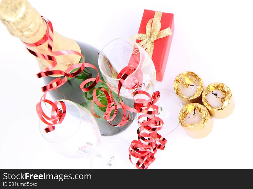 Bottle of champagne, glasses, candles, christmas ball, a gift and cones. Bottle of champagne, glasses, candles, christmas ball, a gift and cones