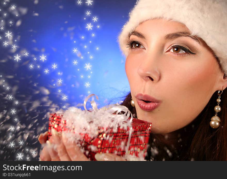 Cute young woman blows snowflakes. Cute young woman blows snowflakes