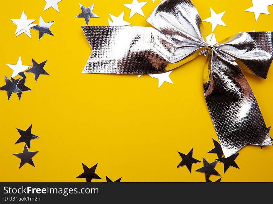 Silver Bow And Stars On The Yellow Background