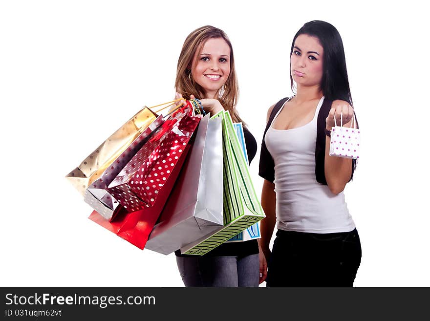 Two girls holding shopping bags, one happy and the other disappointed, on a white background. Two girls holding shopping bags, one happy and the other disappointed, on a white background.