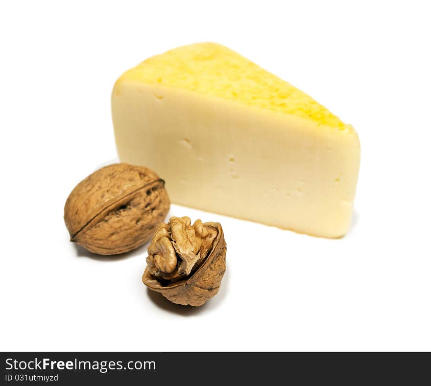 Yellow cheese and walnuts isolated on white background.