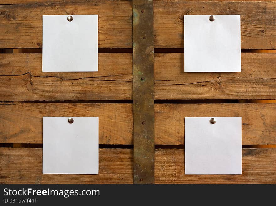 Four pieces of blank paper tacked to wooden background.Ready for your text