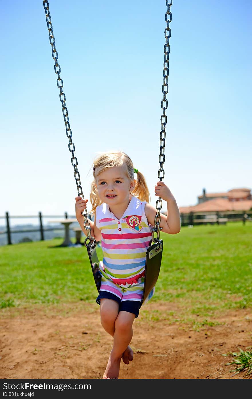 Young child on swing in playground outdoors