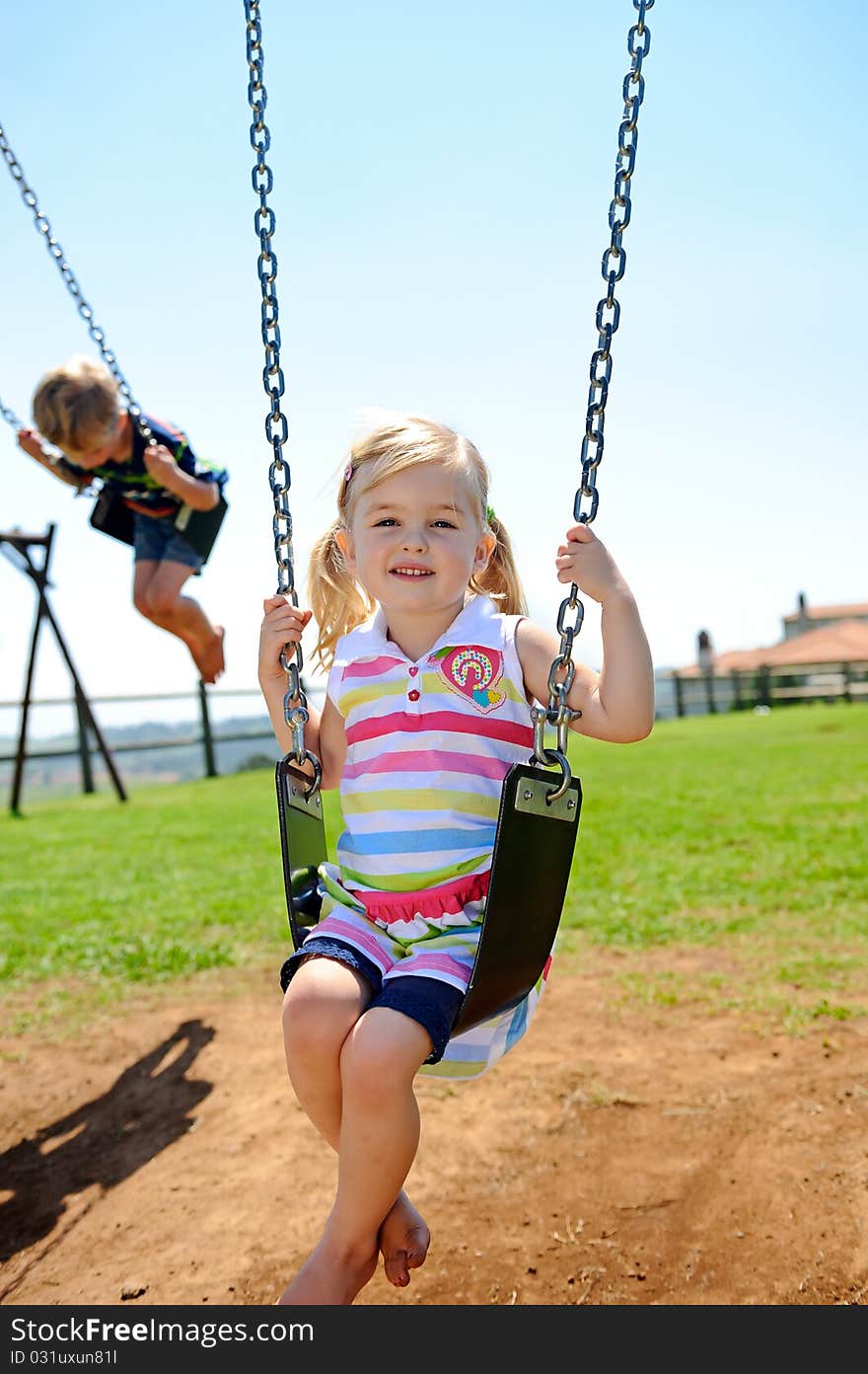 Young child on swing in playground outdoors