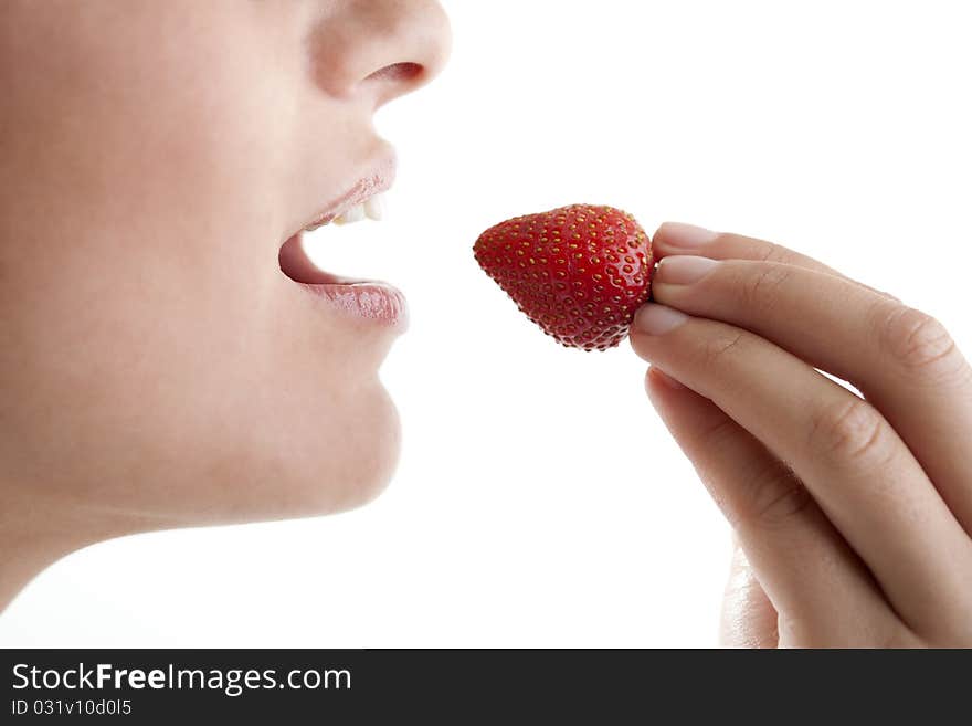 Beautiful young woman eating a fresh strawberry. Beautiful young woman eating a fresh strawberry