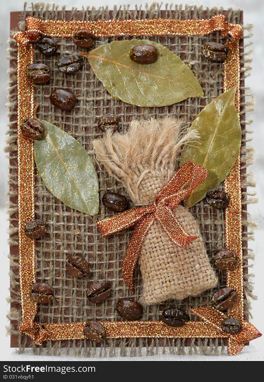 Handmade Card. Sack from coffee, a bay leaf and coffee grains on a sacking.