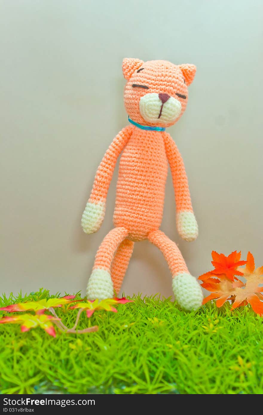 Knitted cat toy isolated on green grass