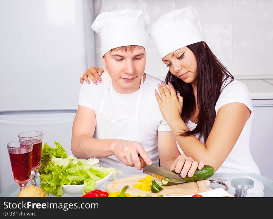 Two happy young cooks making salad in the kitchen. Two happy young cooks making salad in the kitchen