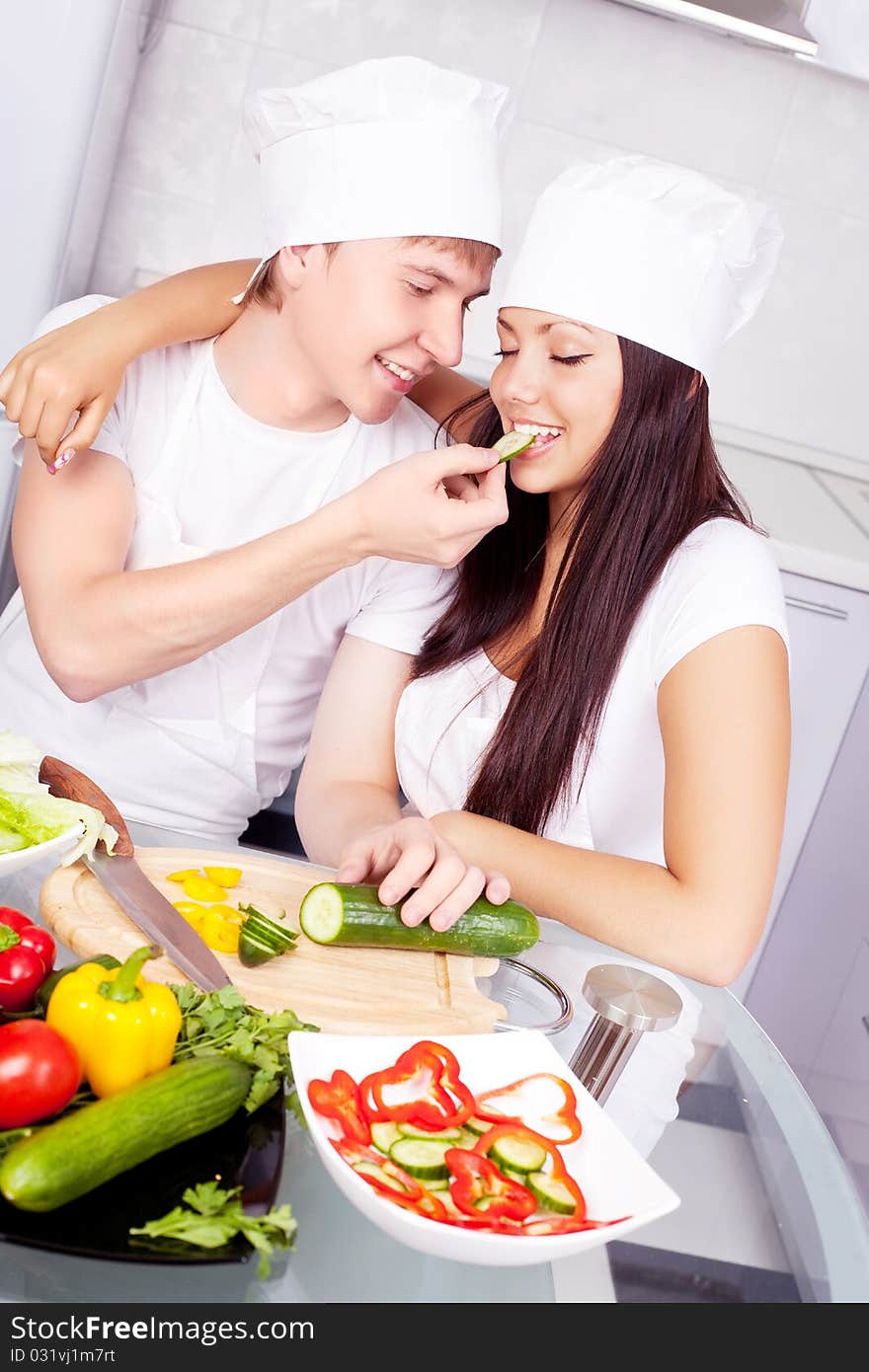 Two happy young cooks making salad in the kitchen. Two happy young cooks making salad in the kitchen