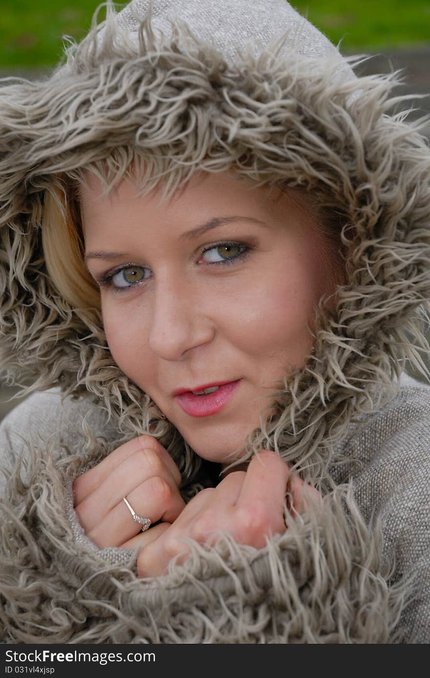 Image showing beautiful young female in warm coat and hood outdoors. Image showing beautiful young female in warm coat and hood outdoors