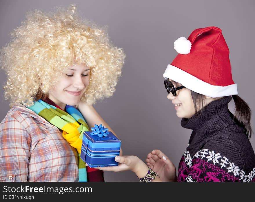 Two beautiful girls with gifts in christmas hats